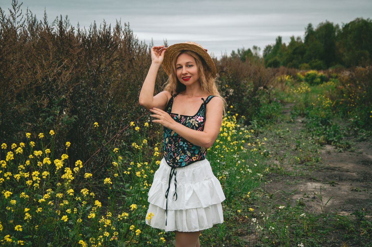Woman in a summer outfit enjoying a wildflower field, exuding a natural and serene vibe.