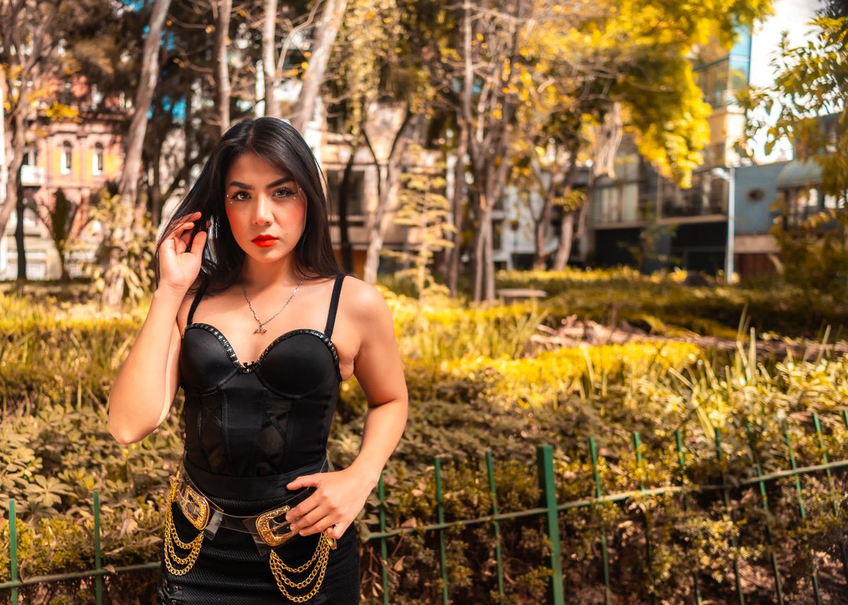 Stylish woman posing in a park in Ciudad de México, wearing a fashionable black dress.