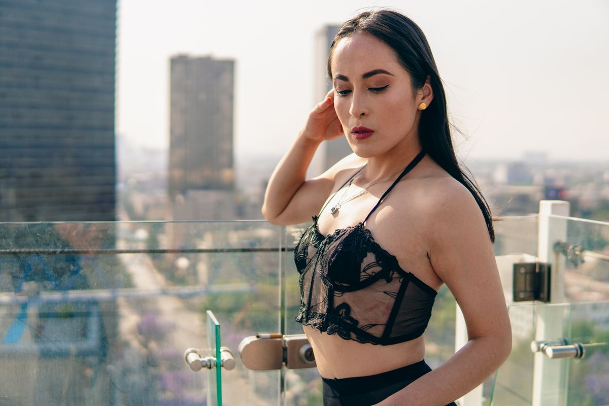 Stylish woman posing on a Mexico City rooftop, showcasing fashion and cityscape.