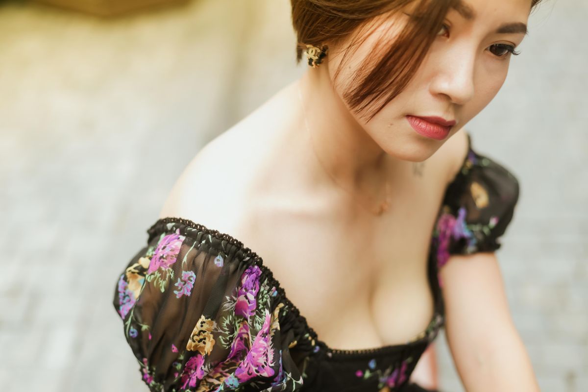 Close-up of an elegant Asian woman in a floral dress, capturing beauty and grace.