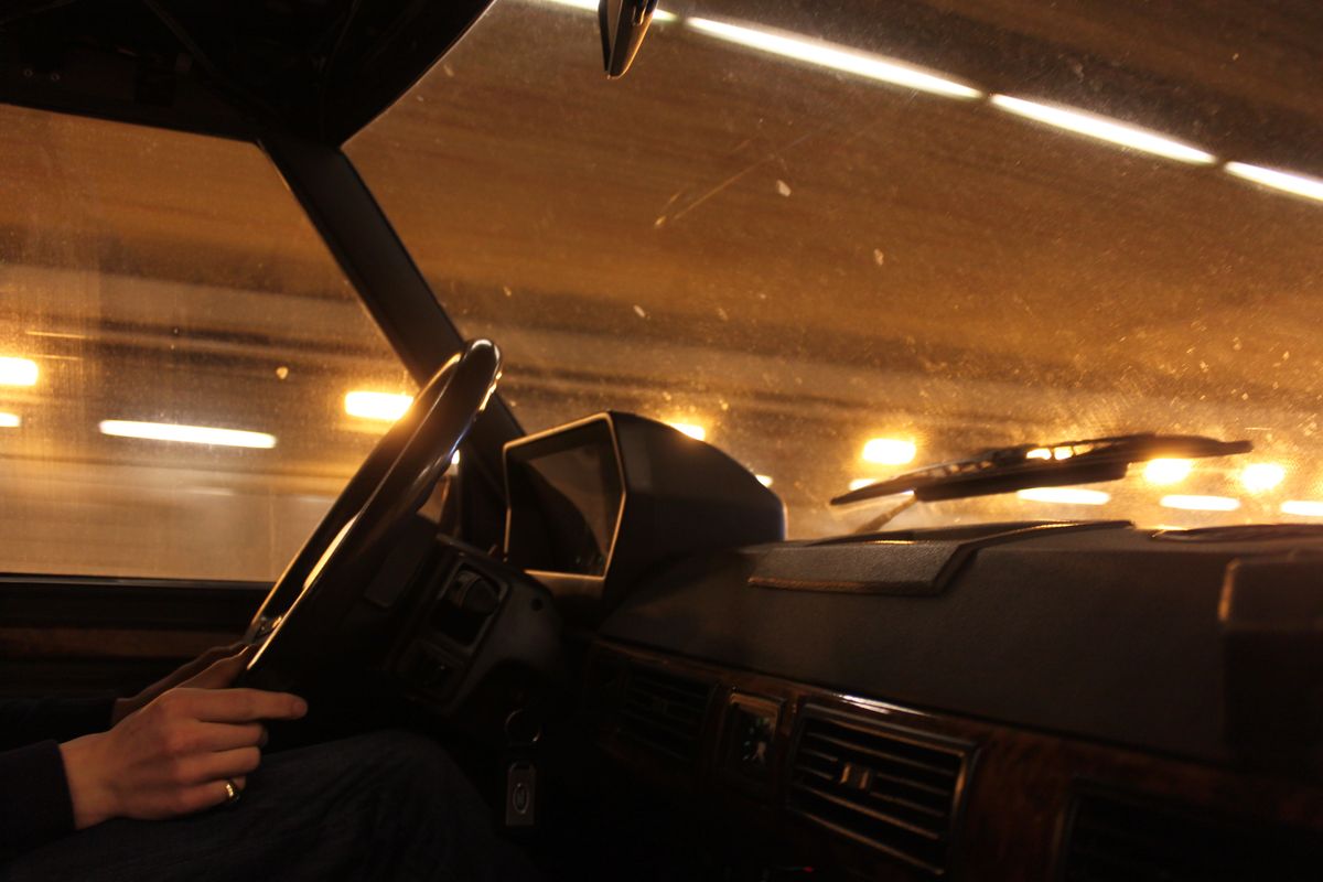 A view from inside a car driving through a brightly lit tunnel at night.