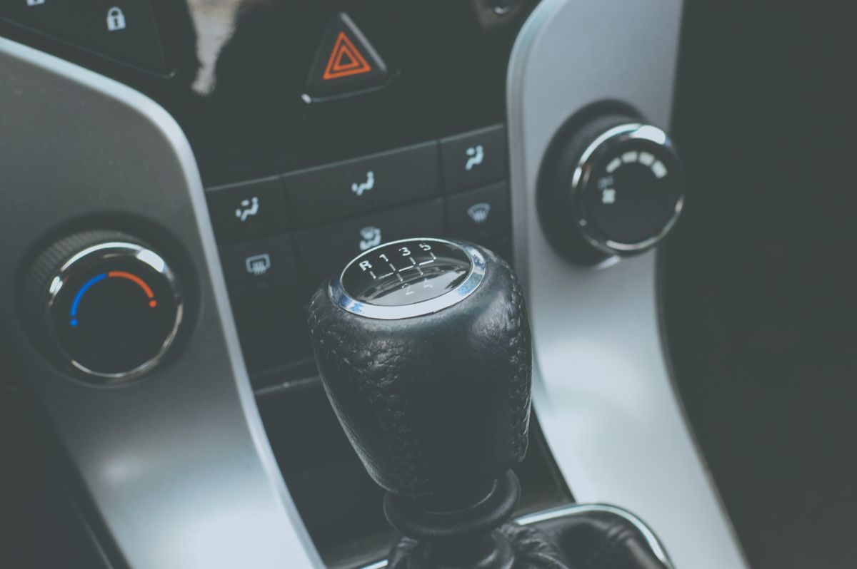 Detailed view of a manual gear shift knob and car console interior.