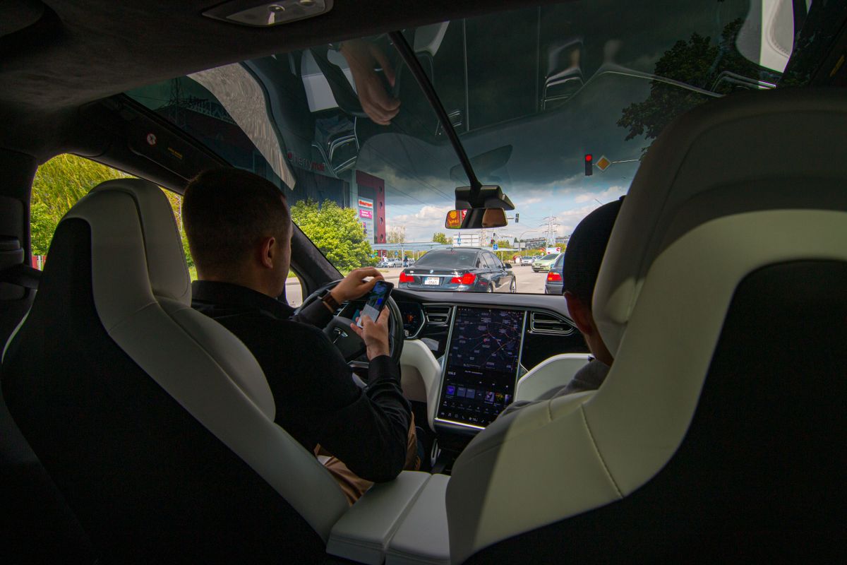 Inside a Tesla vehicle in city traffic, showcasing modern technology and urban driving.