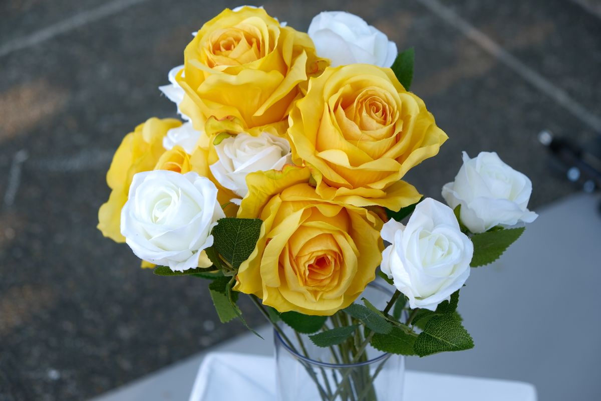 Beautiful bouquet of vivid yellow and white roses in a glass vase, perfect for floral decor.