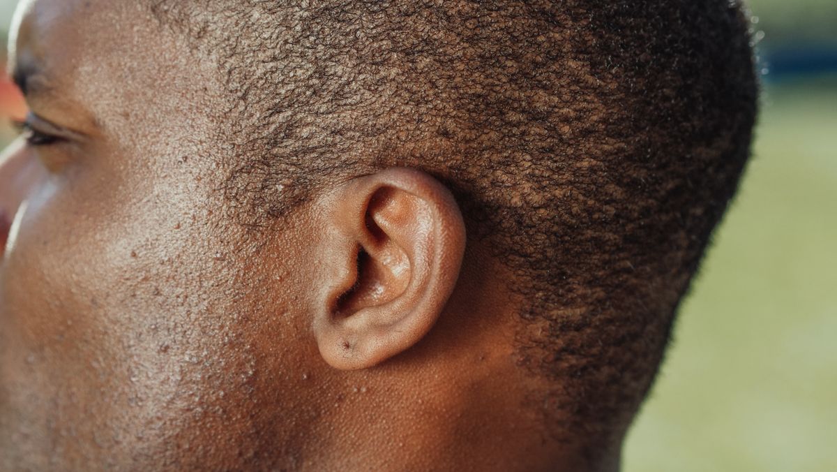 Detailed close-up of a person's ear showcasing skin texture and hair.
