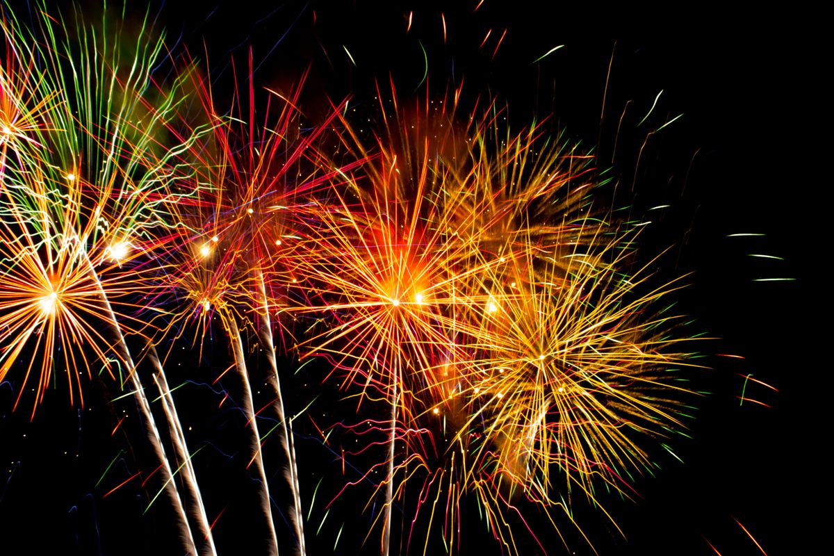 Colorful fireworks explode in the night sky, creating a vivid display of light and color.