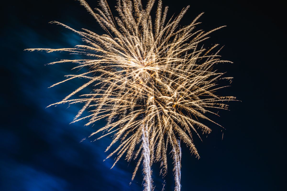 Bright fireworks lighting up a clear night sky during a festive celebration.