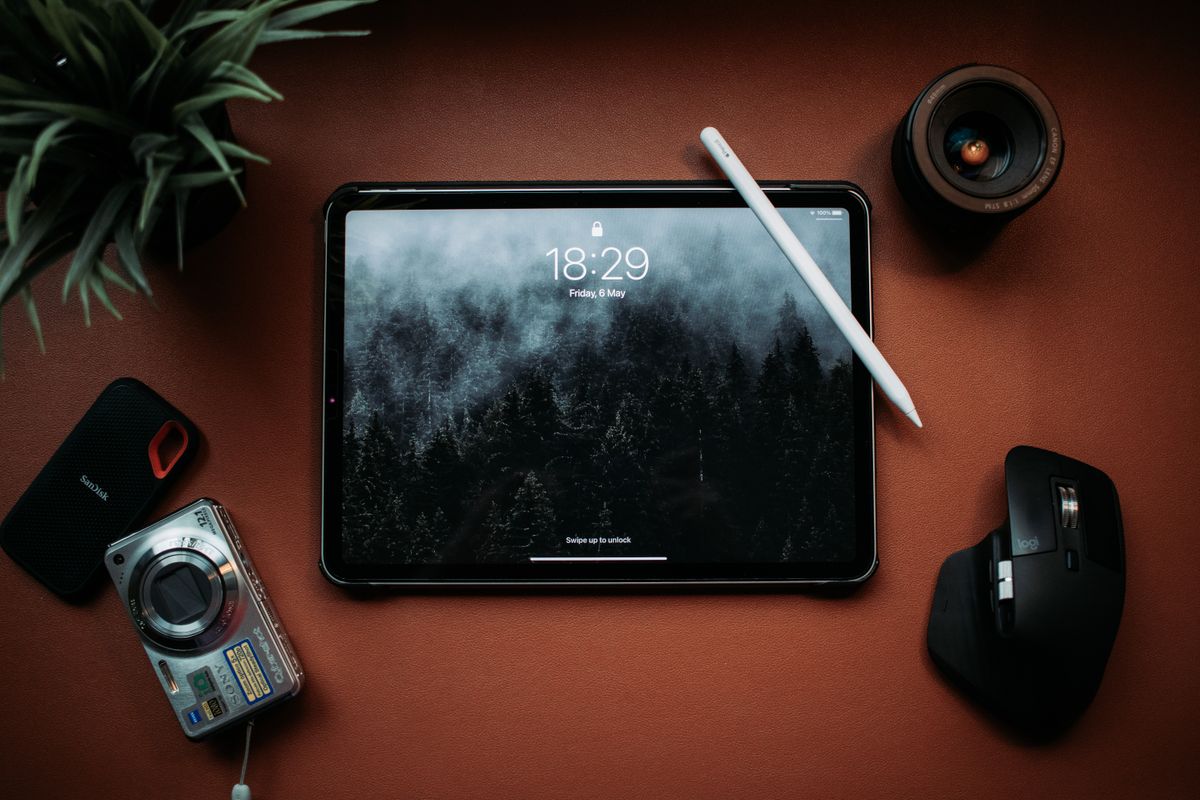Minimalist flat lay of tablet and gadgets on a desk, showcasing modern technology.