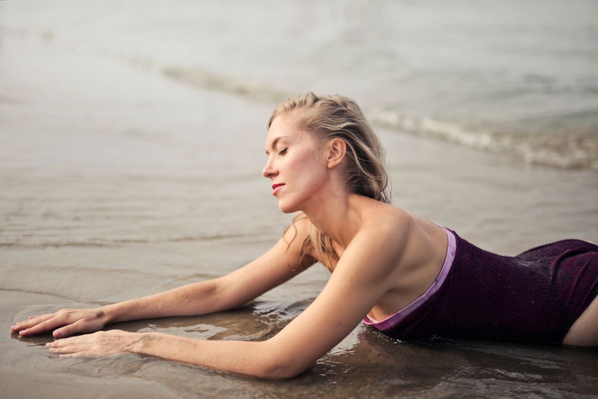 Beautiful woman in swimsuit enjoying a tranquil moment on the beach.