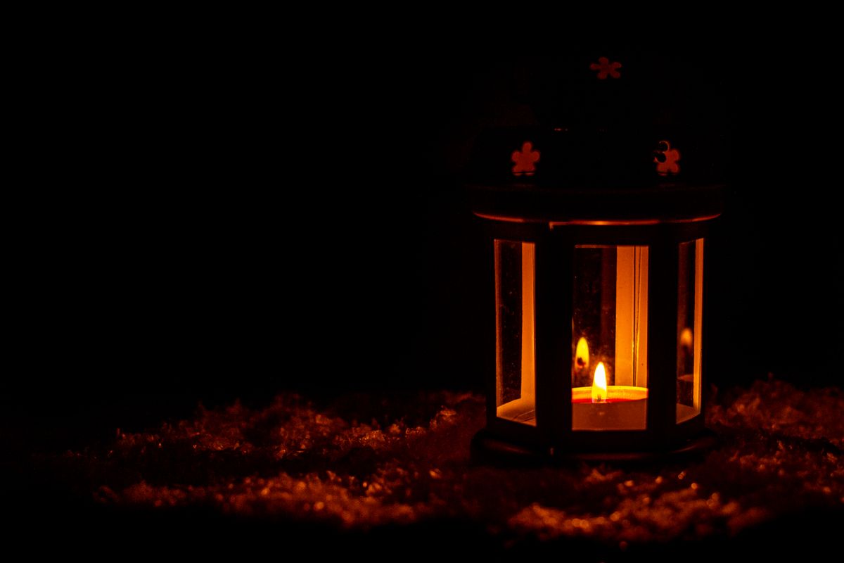 A serene lantern provides warm light against a dark background, evoking a sense of calm and tranquility.
