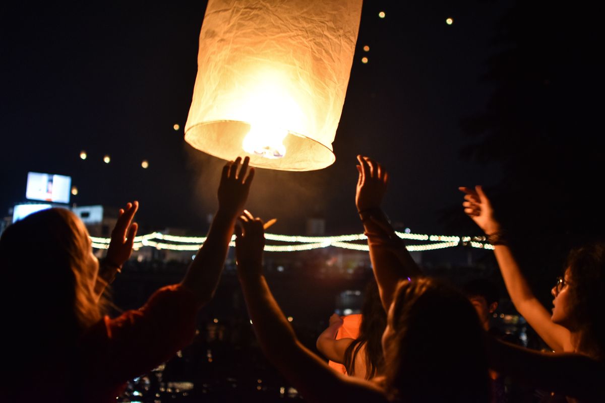 People celebrate by launching a sky lantern at night in Chiang Mai, Thailand.