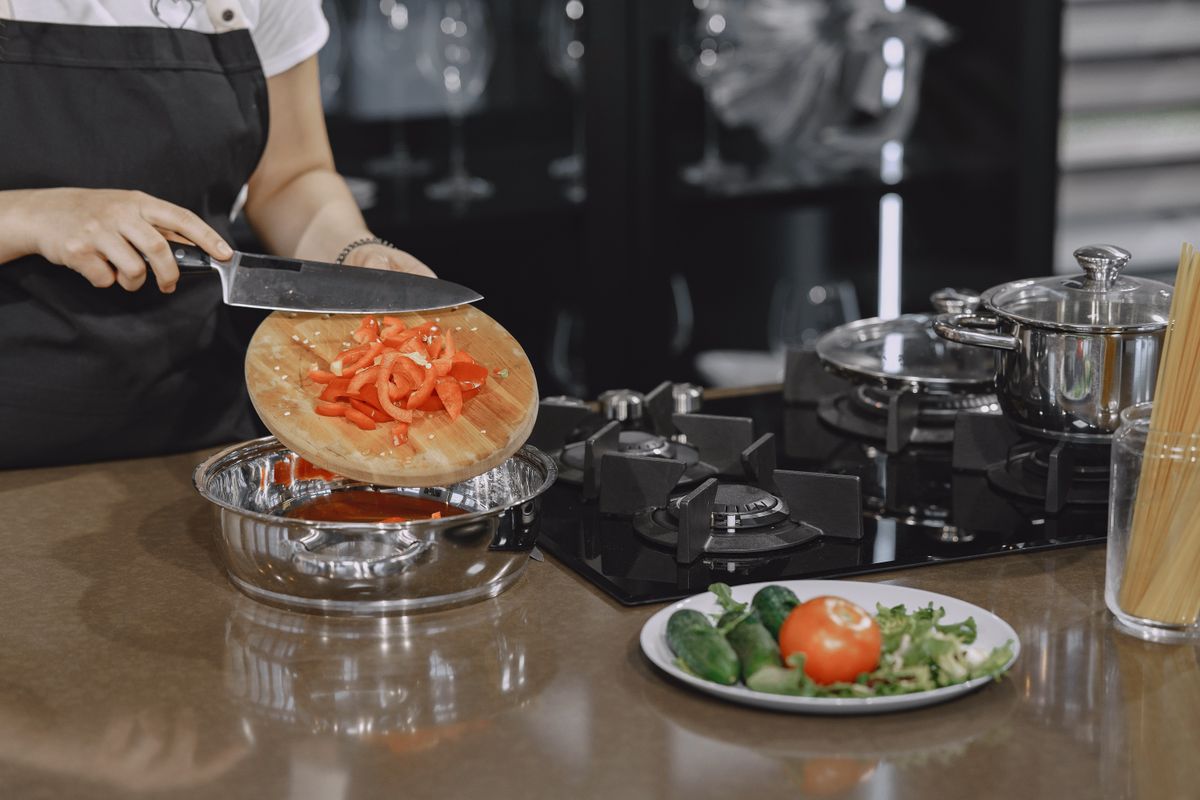A person prepares vegetables on a kitchen counter for a healthy meal.