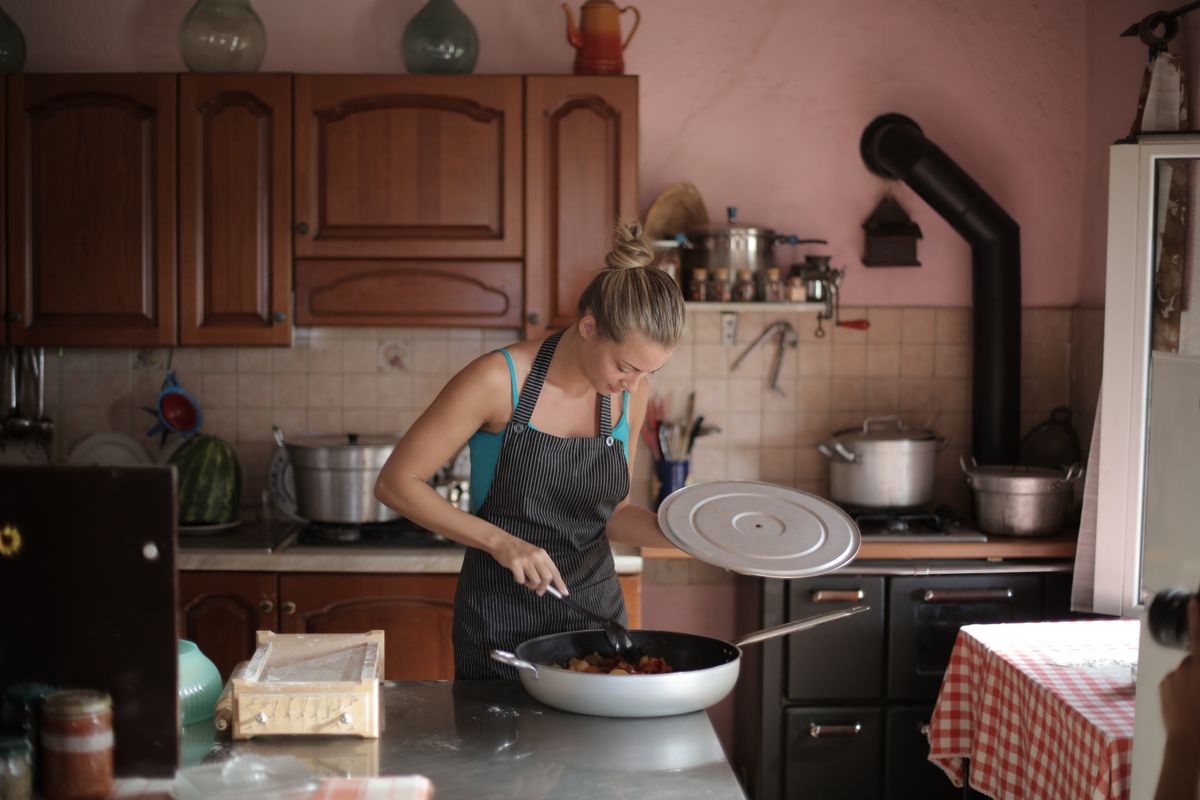 Woman preparing a meal in a rustic kitchen, showcasing home cooking and comfort.