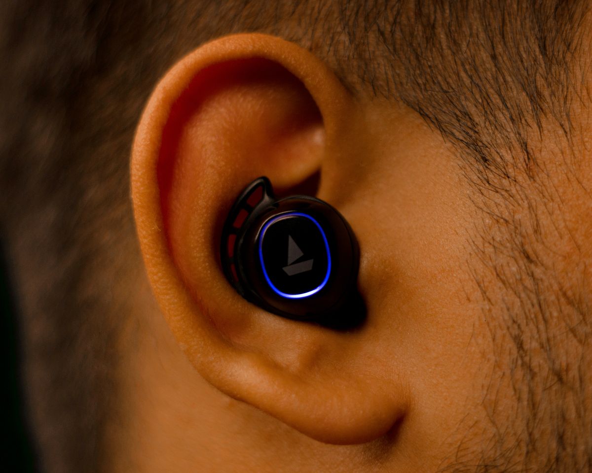 Close-up view of a wireless earbud fitted in a human ear showcasing modern audio technology.