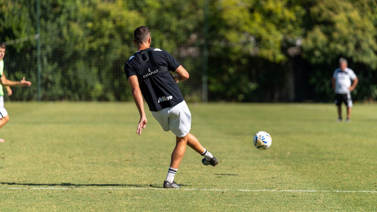 Action shot of a soccer player kicking the ball during an outdoor practice session.