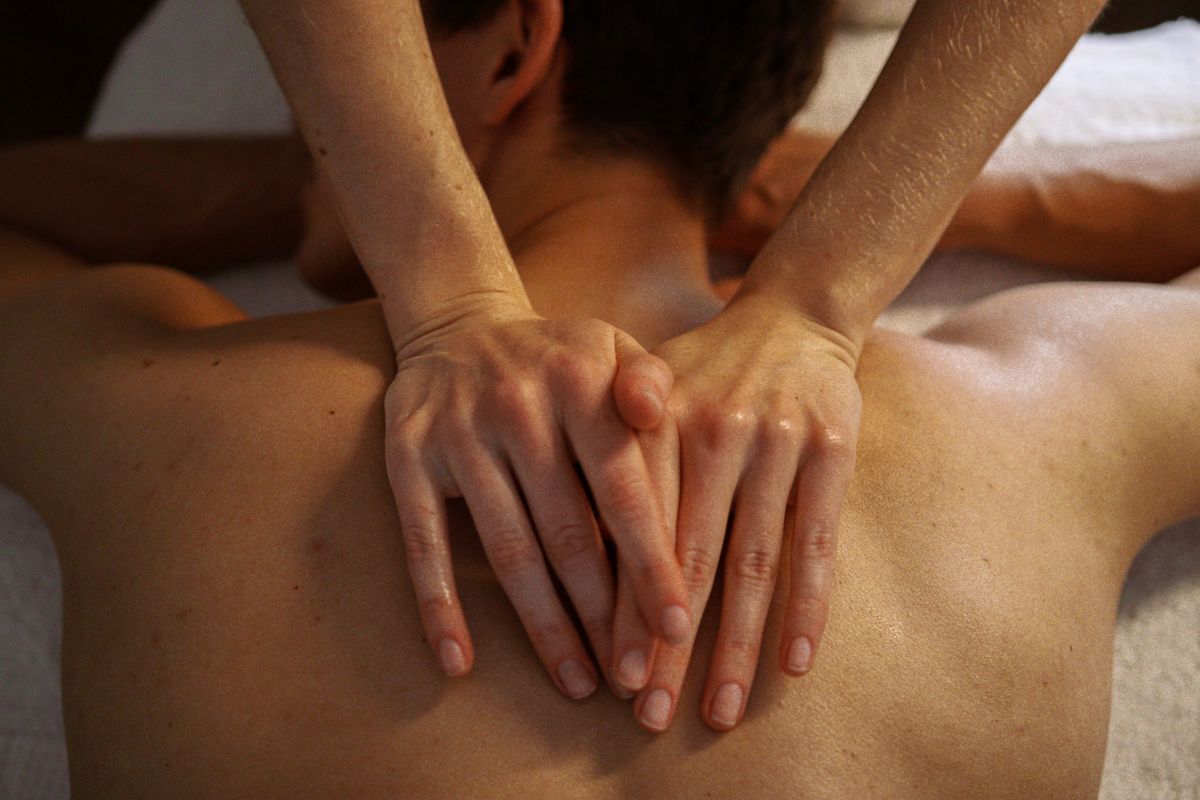 Top view of a relaxing massage session focused on the back with a bokeh effect.