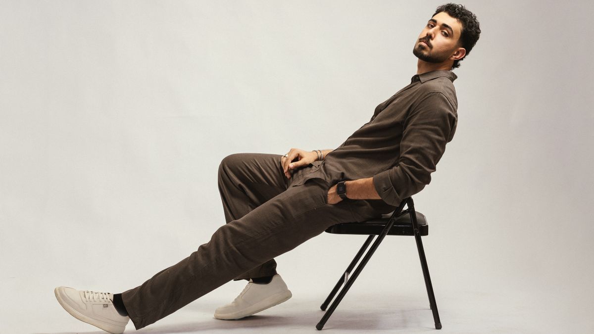 Elegant portrait of a stylish man lounging on a chair in a studio setting. Perfect for lifestyle and fashion themes.