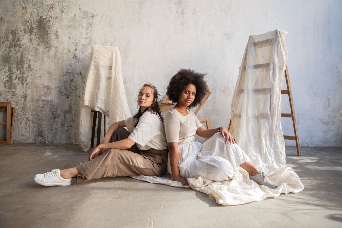 Two stylish women posing indoors, showcasing diverse fashion and style.