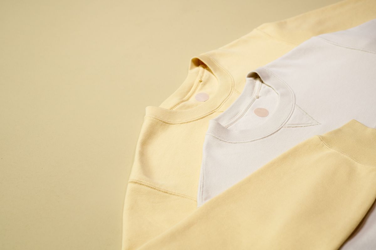 Pastel-colored sweatshirts arranged on a neutral background, emphasizing casual fashion style.