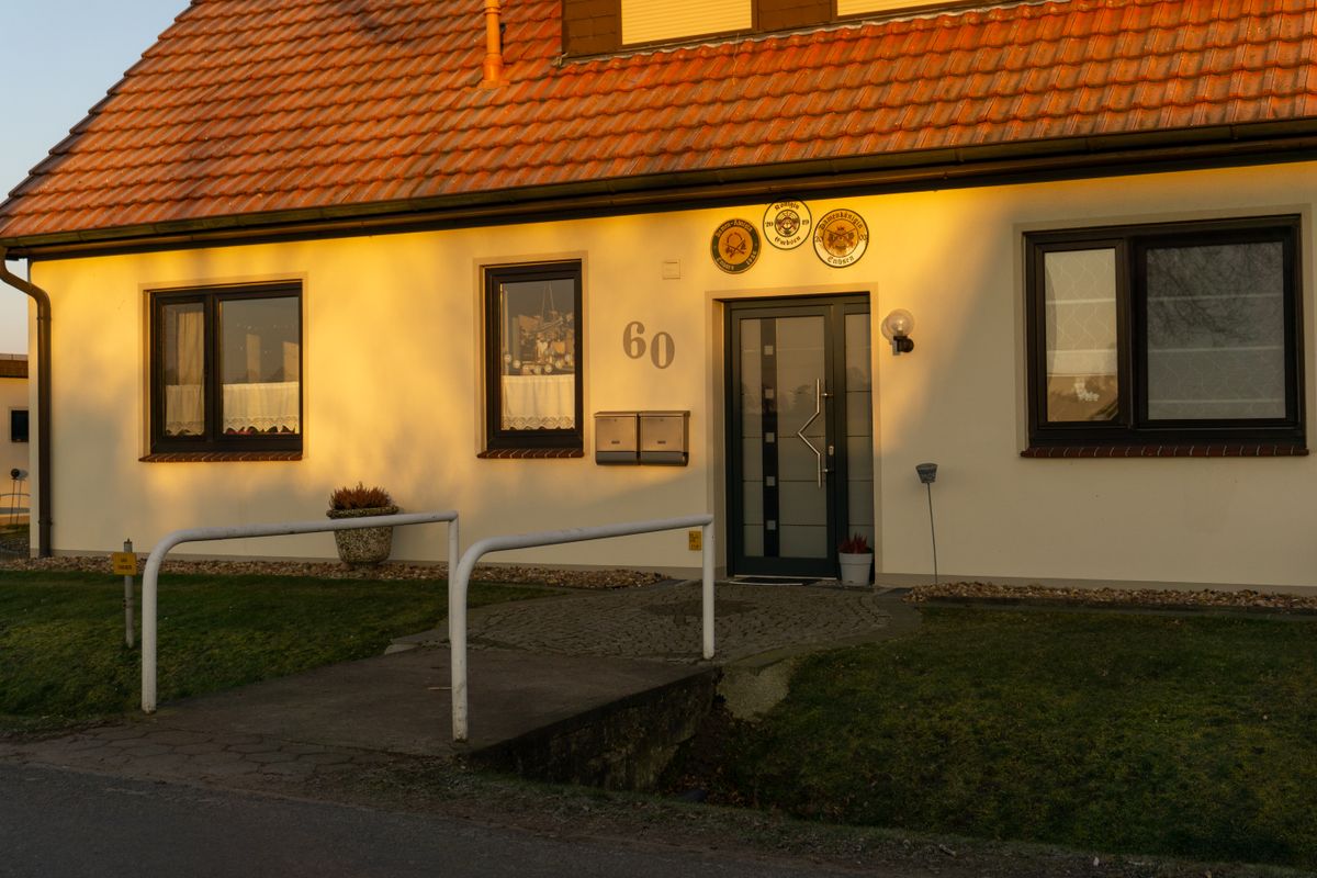 A well-lit, picturesque entrance of a modern home in Achim, Germany during sunset.