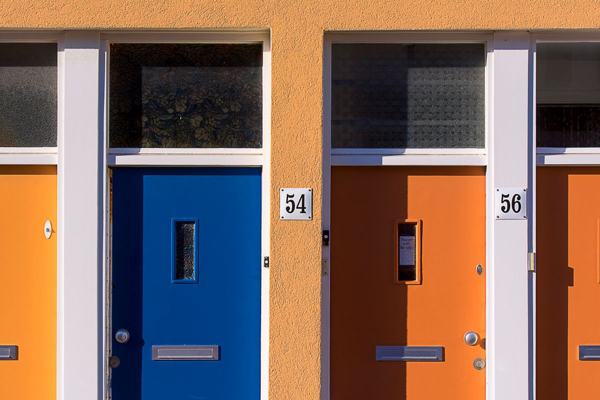 Brightly colored doors with numbers 54 and 56 on a modern building facade.