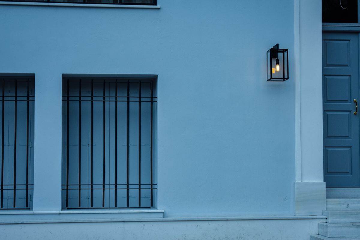 Stylish blue building facade with a modern lantern and door in Athens, Greece.