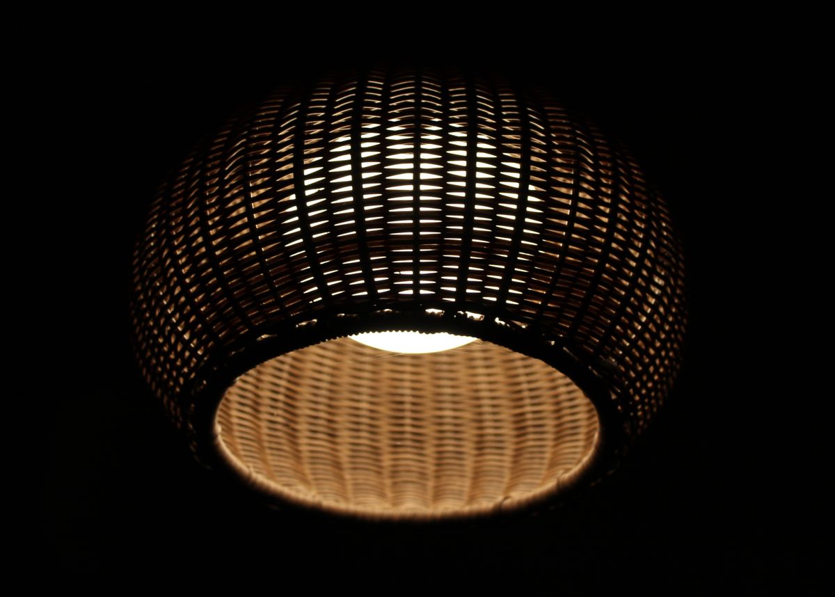 A beautifully illuminated handmade wicker lamp casting warm light in the dark.
