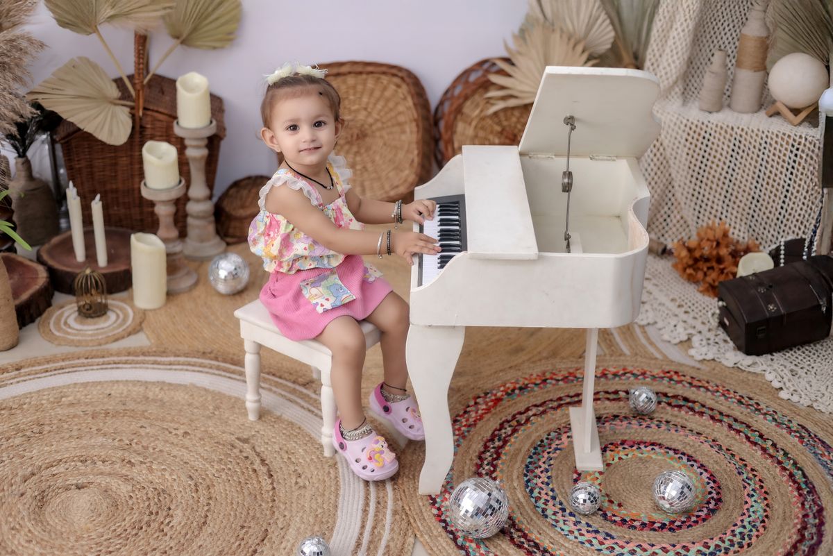 A cute child playing a toy piano in a beautifully decorated room, showcasing creativity and charm.