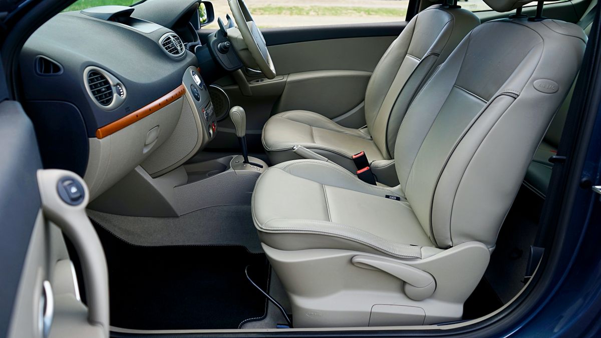 Luxurious car interior with beige leather seats and sleek dashboard.