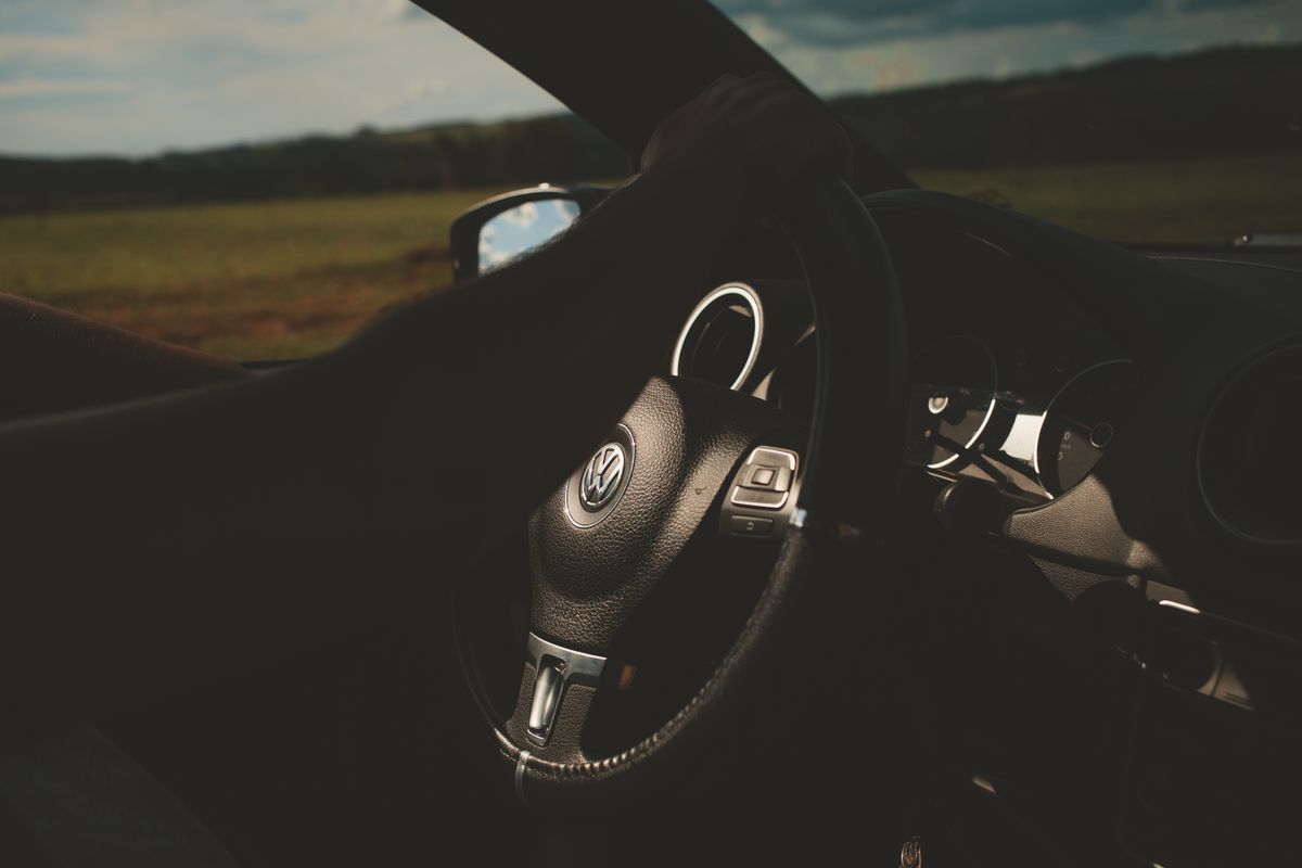 Close-up of a car interior with a focus on the steering wheel and dashboard.
