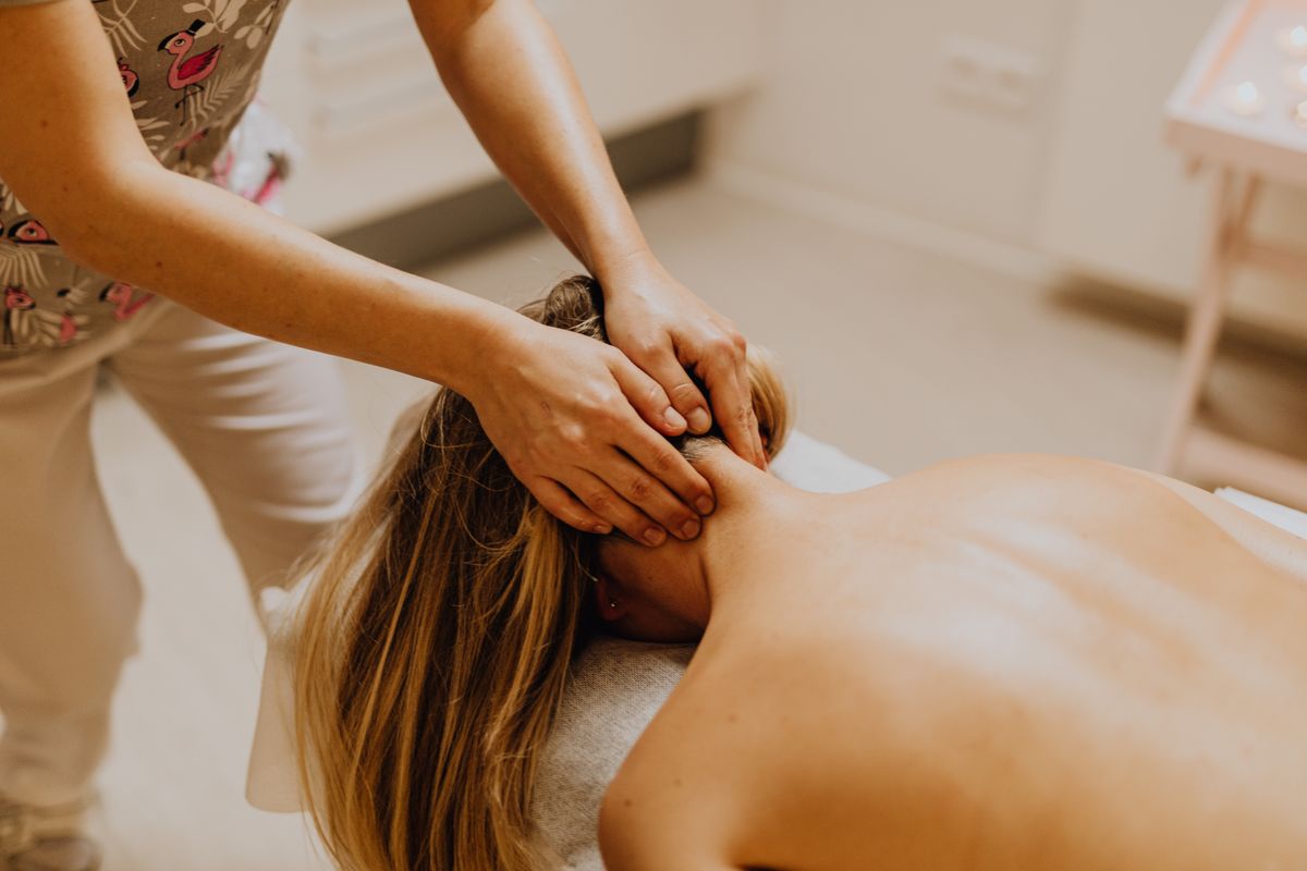 Woman receiving a relaxing neck massage during a therapy session, promoting wellness and tranquility.