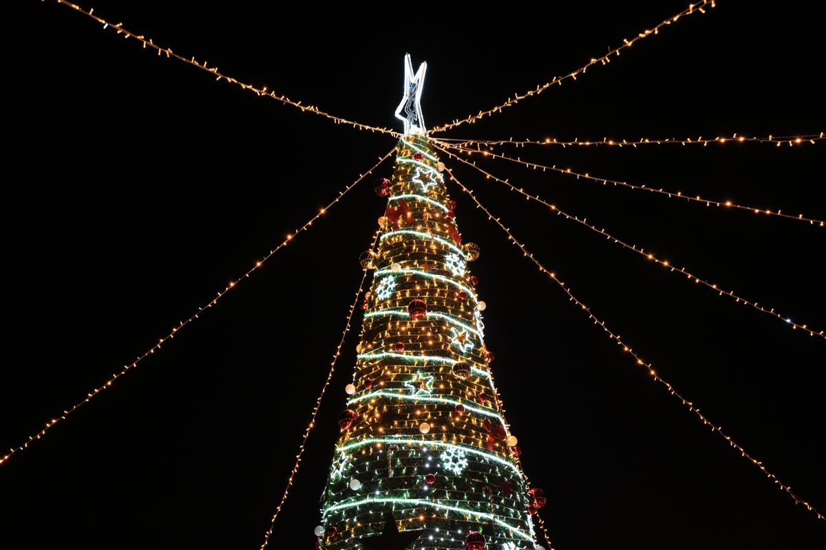 A vibrant Christmas tree adorned with lights and decorations against a night sky in Bursa, Türkiye.