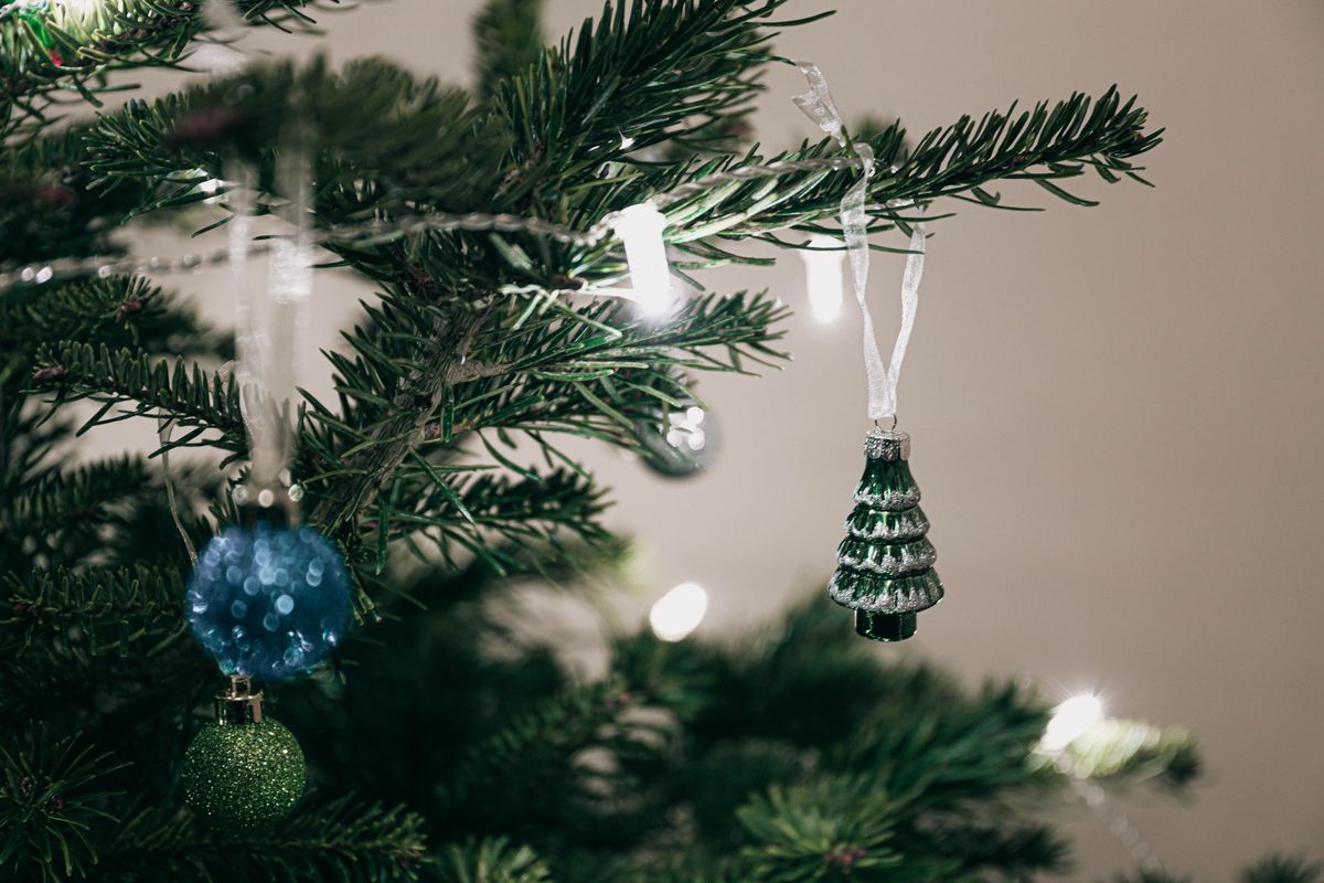 Festive Christmas tree decorated with ornaments and lights captured indoors.