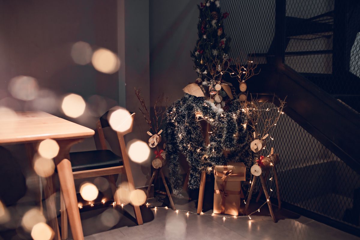 Warm indoor Christmas setting with ornaments, lights, and festive tree.