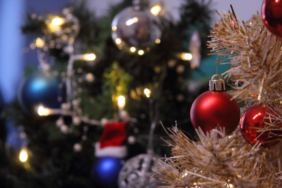 Close-up of a Christmas tree adorned with lights and colorful ornaments.