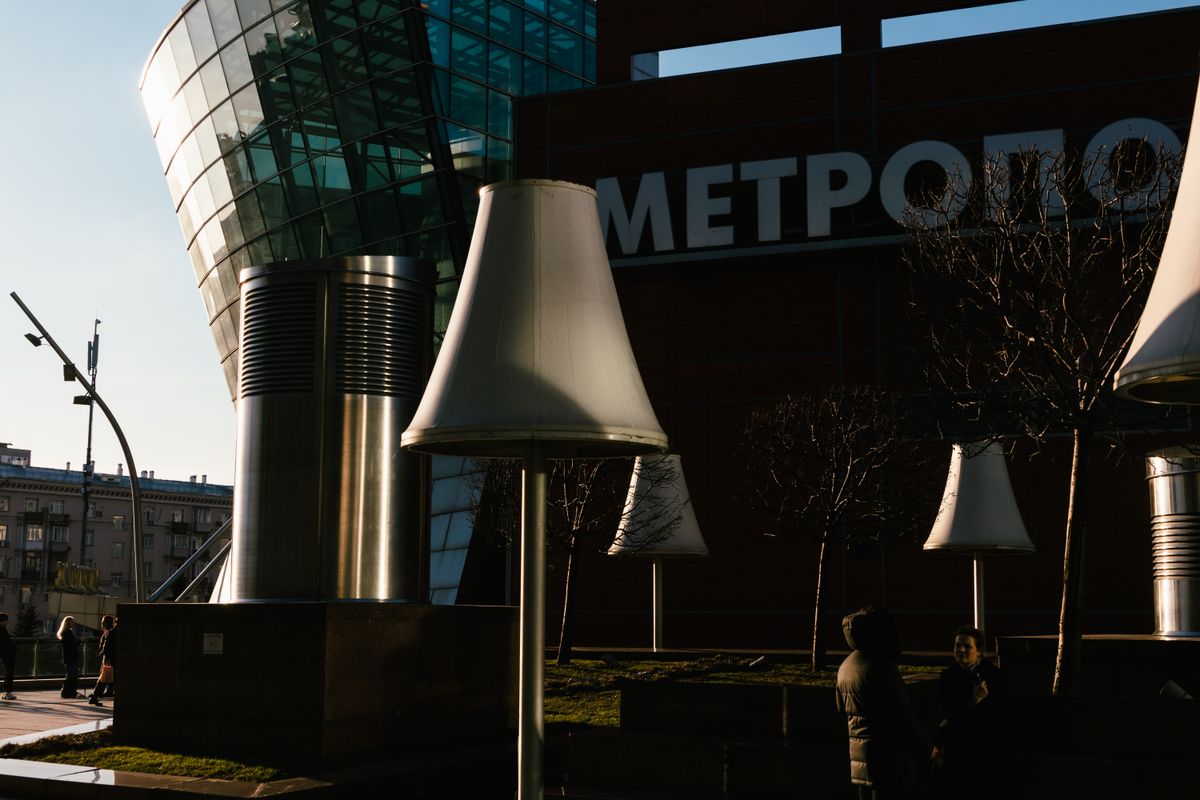 Cityscape featuring modern architecture and unique outdoor lamp sculptures at dusk.