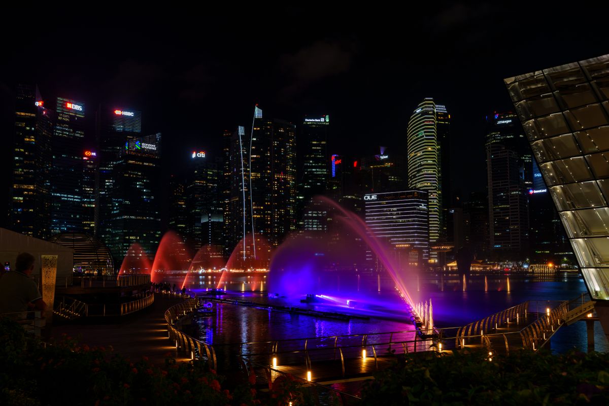 Stunning night view of Marina Bay Sands with colorful water fountain and city lights.