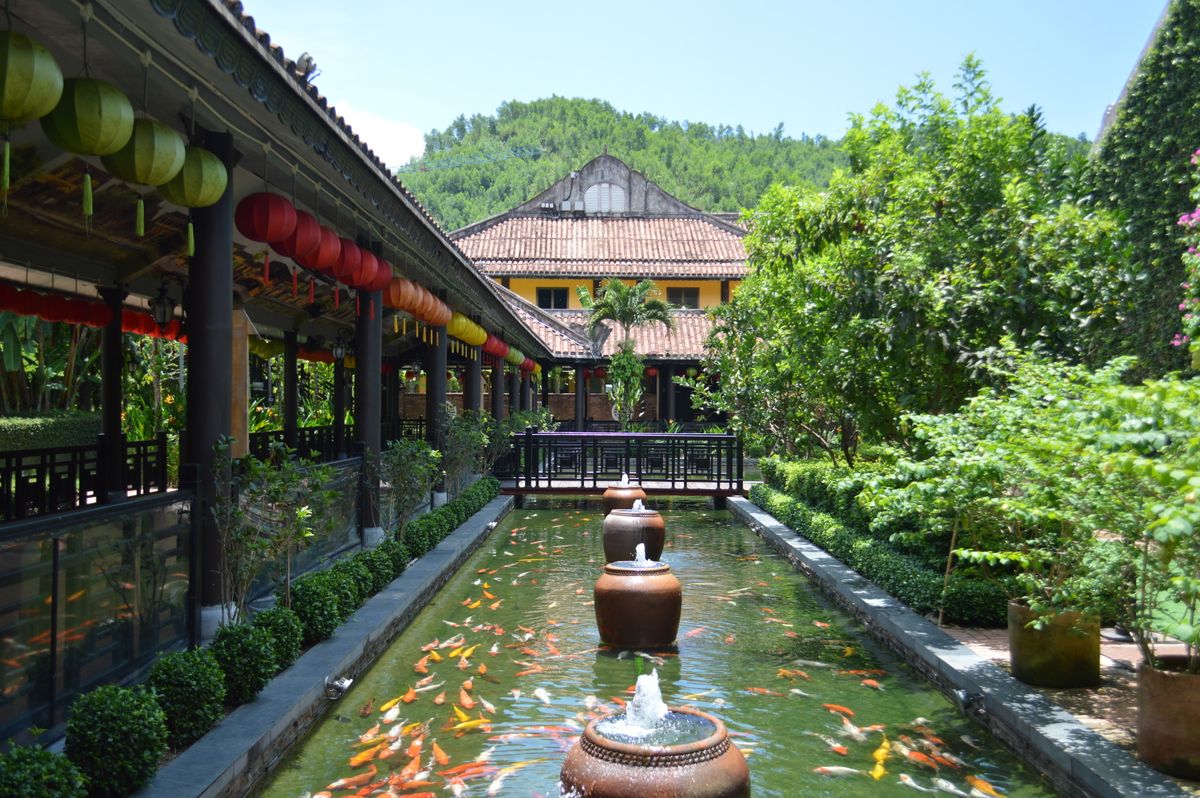 Beautiful Asian garden with koi pond and colorful lanterns under a clear sky.