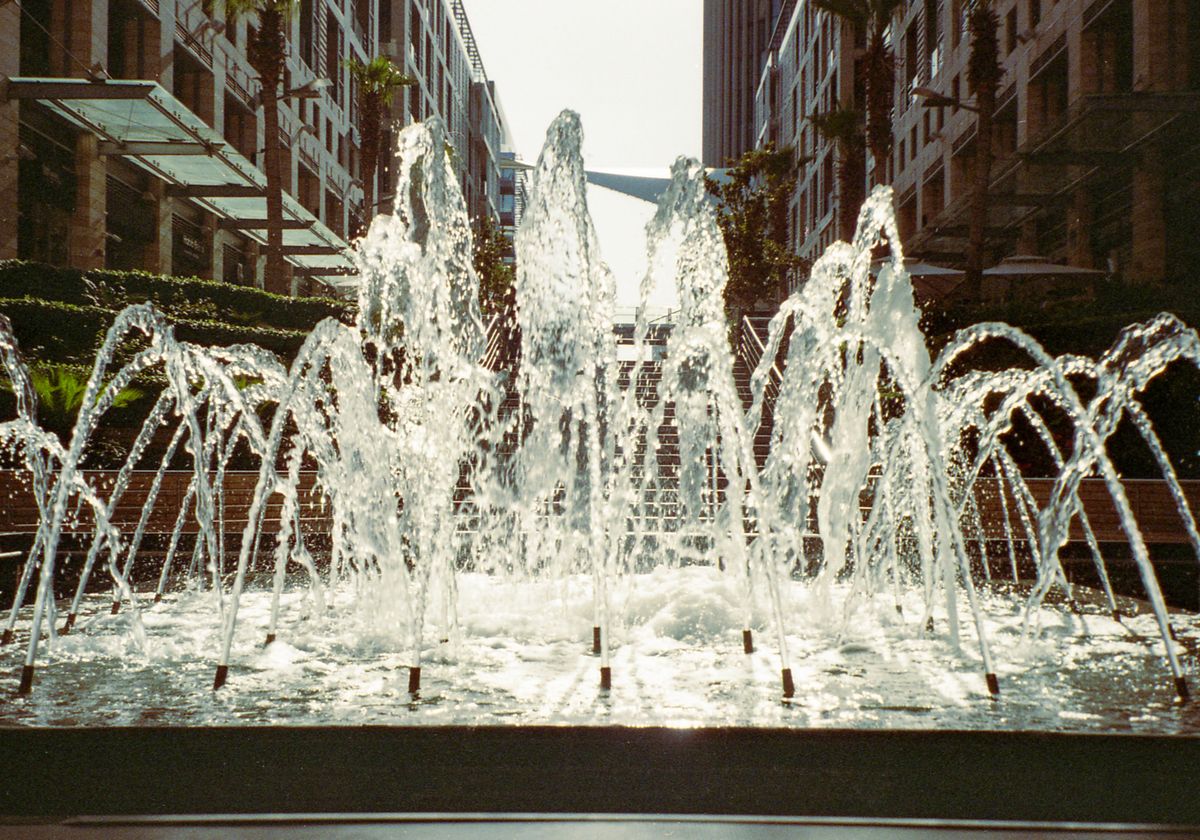 A vibrant water fountain surrounded by modern architecture in Amman's urban landscape.