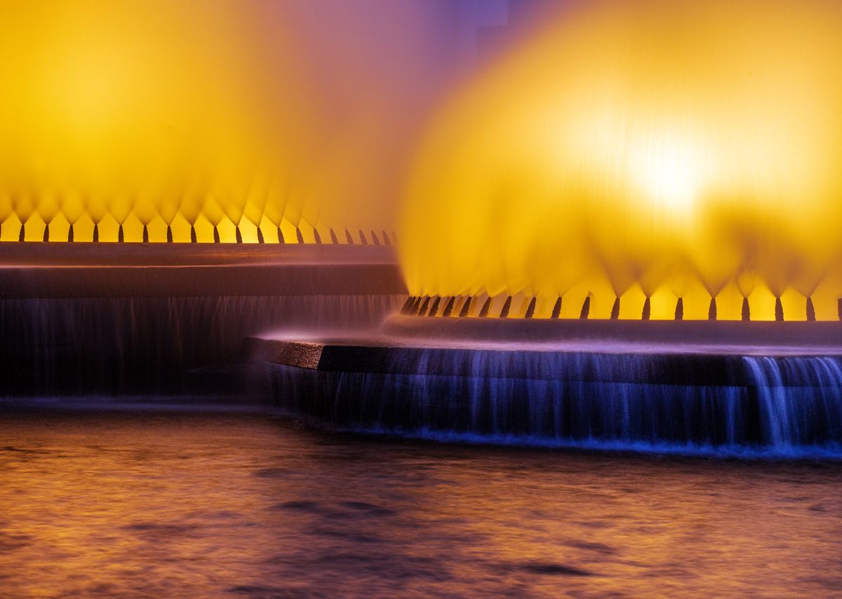 Captivating view of an illuminated fountain at night with vibrant colors and water reflections in Brazil.
