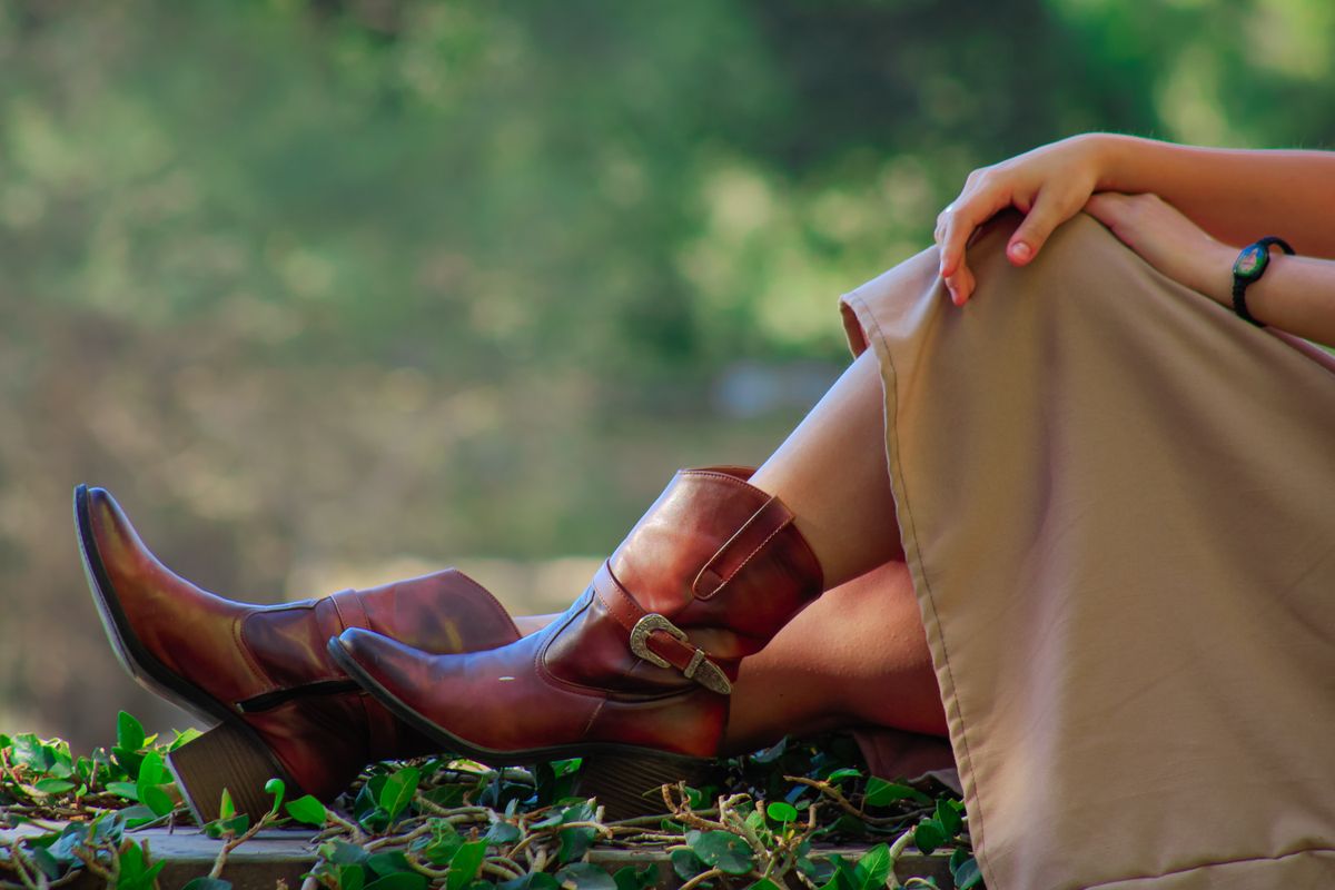 Woman relaxing outdoors wearing cowboy boots in Guanajuato's natural setting.