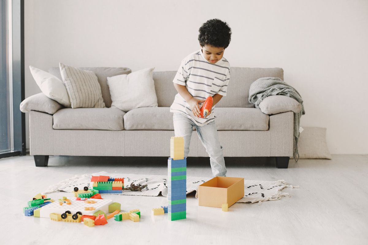 A cheerful child playing with colorful building blocks indoors.