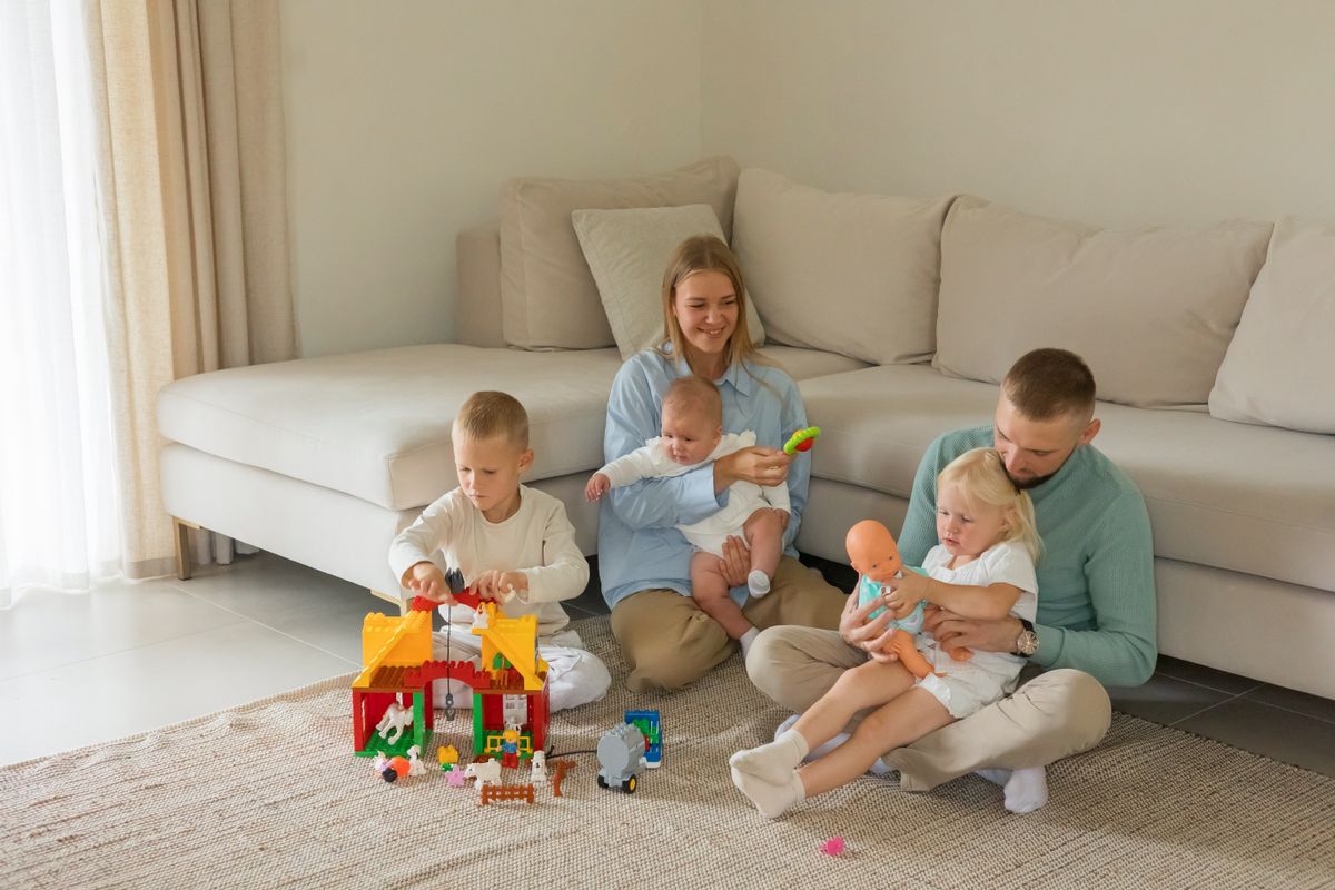 A cheerful family enjoying playtime with toys in a modern living room setting.