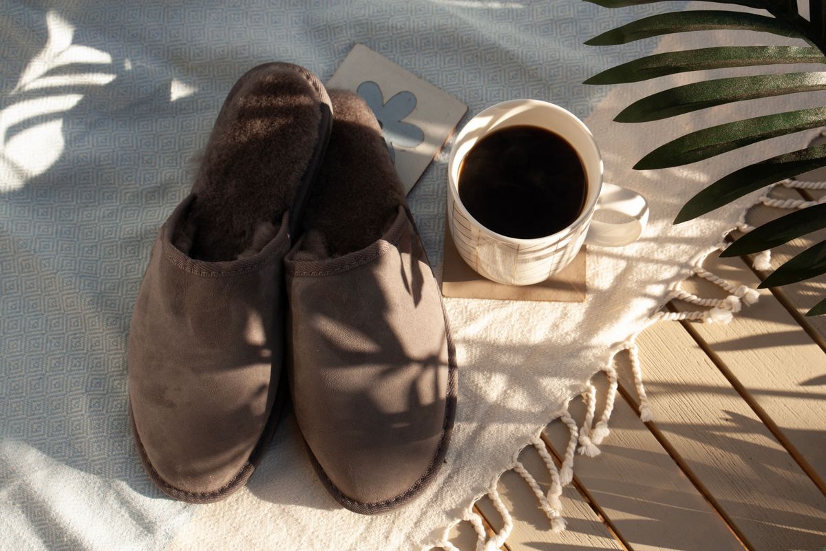 Warm morning scene with cozy slippers and coffee on a sunlit deck, perfect for relaxation.