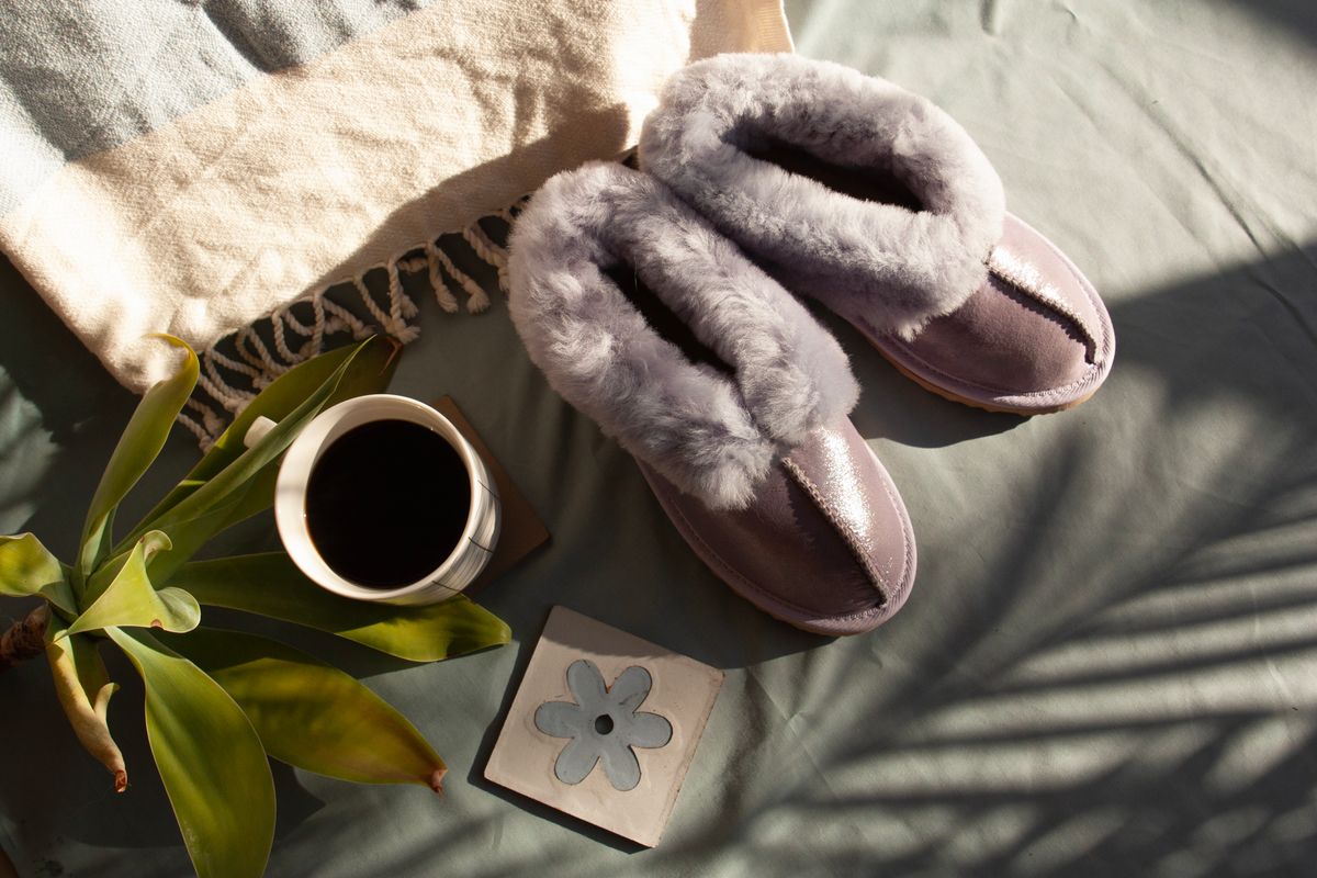 Warm slippers, coffee, and plants create a cozy morning ambiance. Perfect for relaxation and comfort.