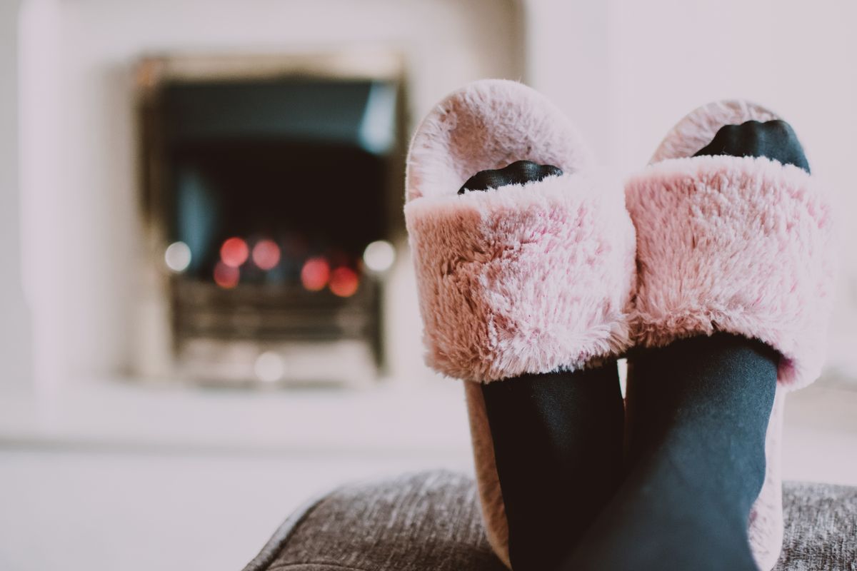 Relaxing by the fireplace with fuzzy slippers and warm socks indoors.