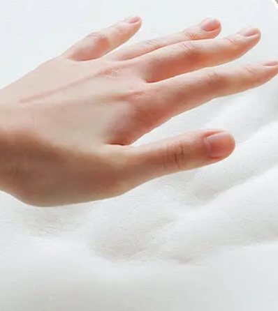 A hand pressing into the slow-rebound memory foam