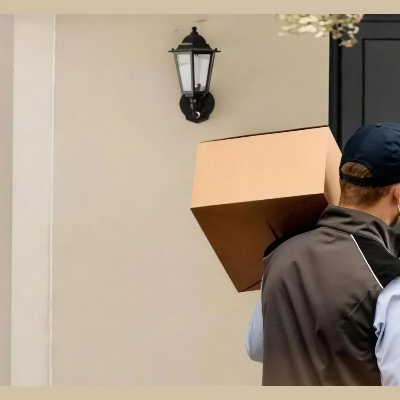 A delivery driver setting a parcel down by a front door
