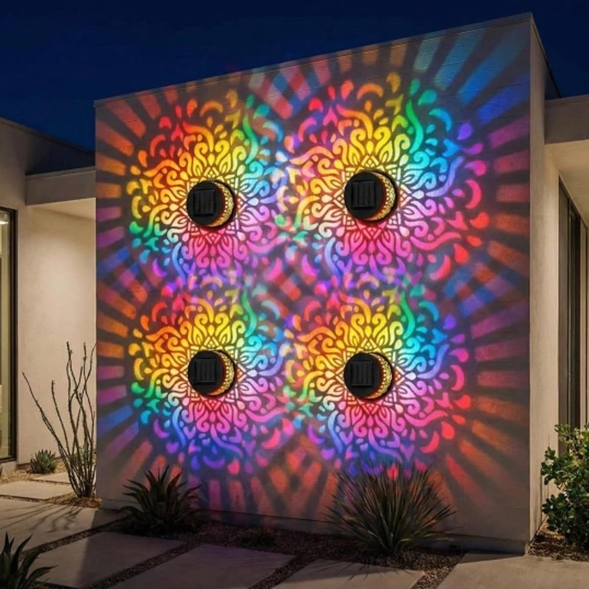 Four solar mandala lights projecting a vivid seven-color mandala across a wall at night