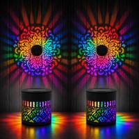 Two mandala lights glowing rainbow on dark wood